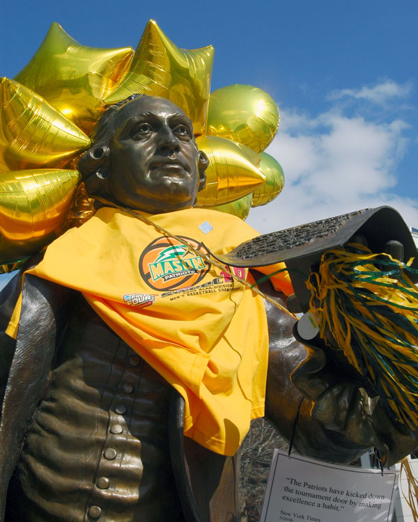 George Mason statue decorated for Mason's basketball team's participation in the NCAA Final Four championship. Statue draped with Mason T-shirt and adorned with mardi gras beads and gold balloons. 