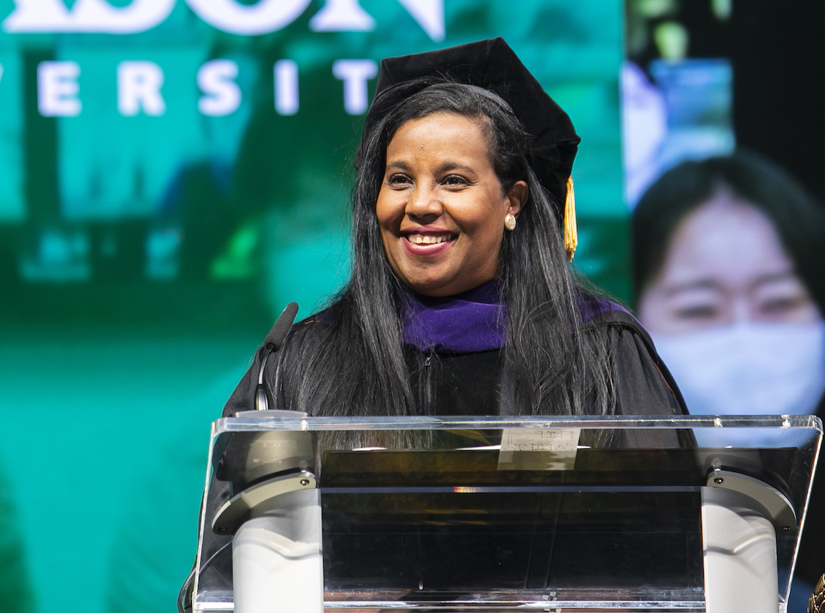 woman in cap and gown at podium