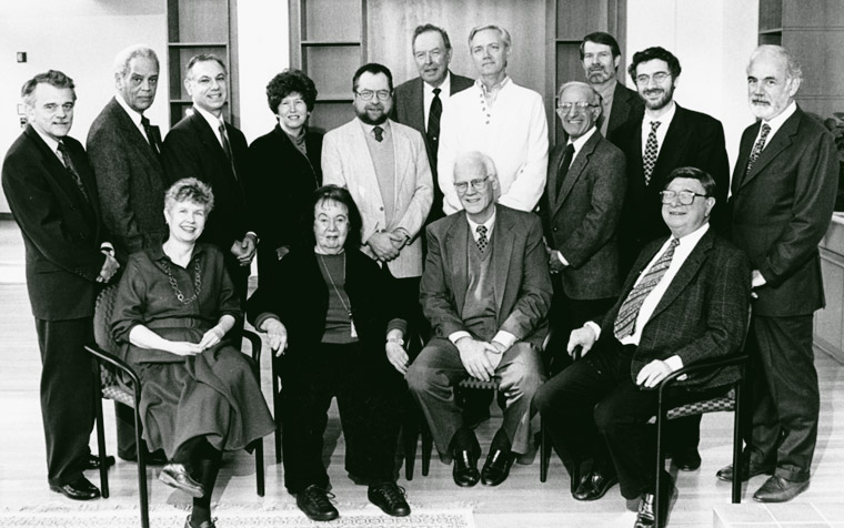 black and white photo of a group of professor in front of bookcases