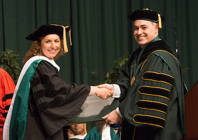 woman and man in regalia shaking hands