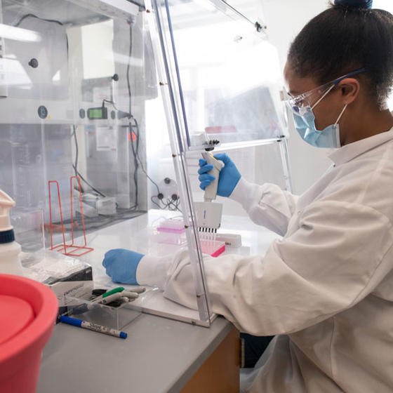 Researcher uses pipettes to measure samples at the Institute for Biohealth Innovation at George Mason University