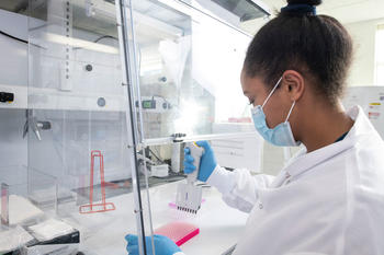Researcher uses test tubes and pipette in a lab environment