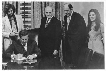 Linwoo Holton signs the legal charter of George Mason University as governor of Virginia
