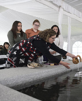 Gabrielle Tayac pours water into the fountain at the dedication of the Enslaved People of George Mason Memorial